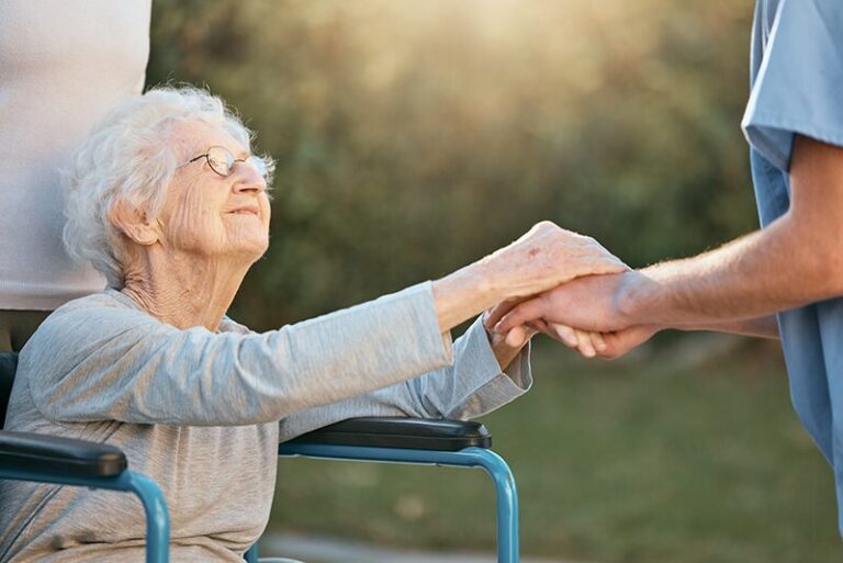Une personne âgée sur un fauteuil roulant qui échange avec une infirmière de l'établissement à la sortie du conseil de vie sociale (CVS)