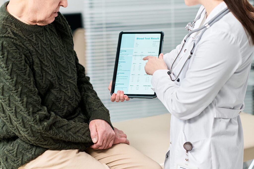 Patient âgé consultant les résultats de son débit de filtration glomérulaire (DFG) avec un médecin