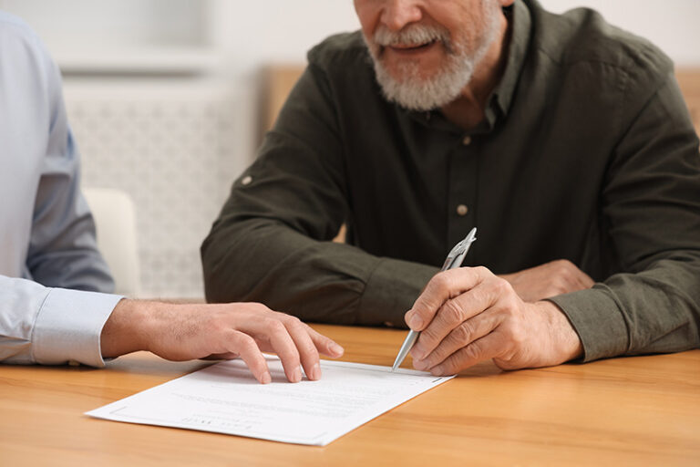 Une personne âgée remplit son formulaire de demande du minimum vieillesse, guidée par un conseiller.