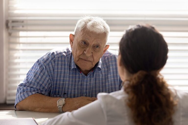 Une personne âgée assise face à son médecin qui lui fait passer un test codex, de dépistage cognitif