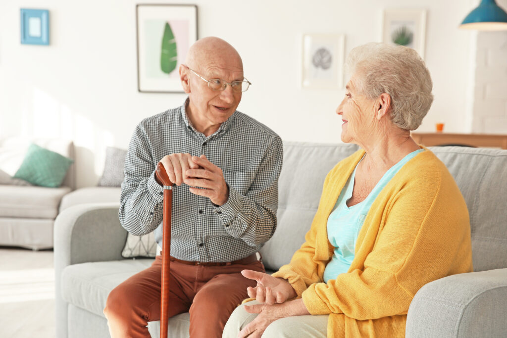 Deux personnes âgées discutent de CetteFamille sur un canapé