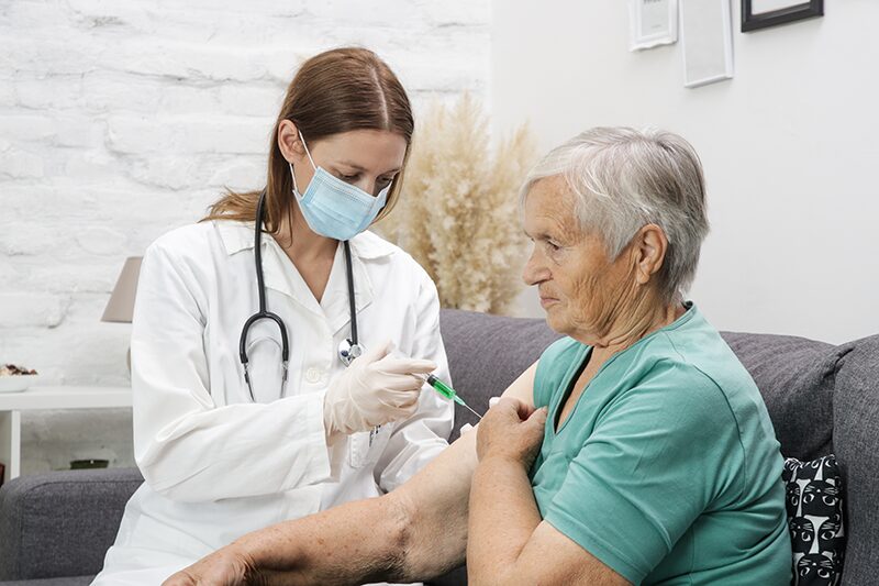 Une médecin administre une injection à une femme âgée afin de traiter son taux de créatine qui est bas