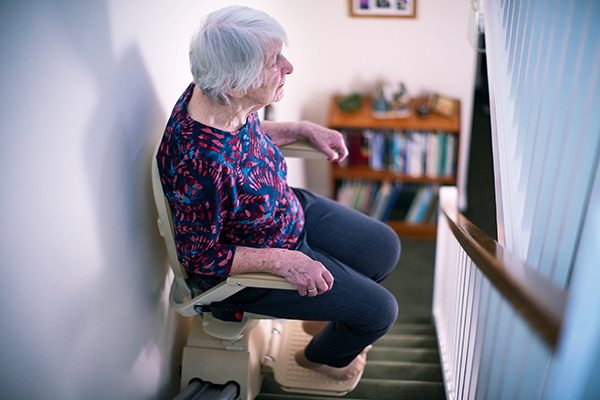 Une personne âgée utilise son monte-escalier chez elle
