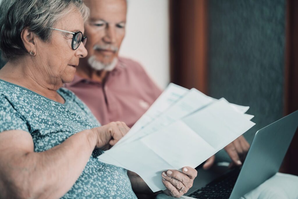 Un couple de personnes âgées en train de lire des documents portant sur la pension de réversion 2026