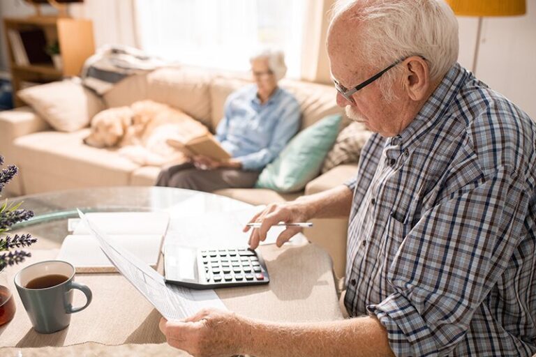 Revalorisation des retraites 2025 : Homme senior assis, concentré sur les calculs de sa retraite pour l'année 2025.